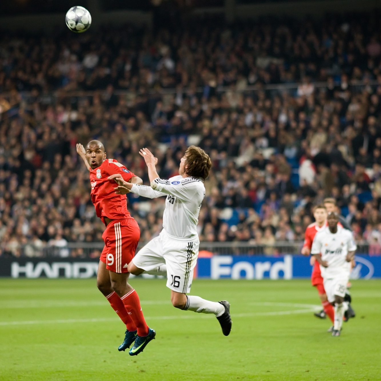 Two players challenge for a header in a game between Bayern Munich and Real Madrid